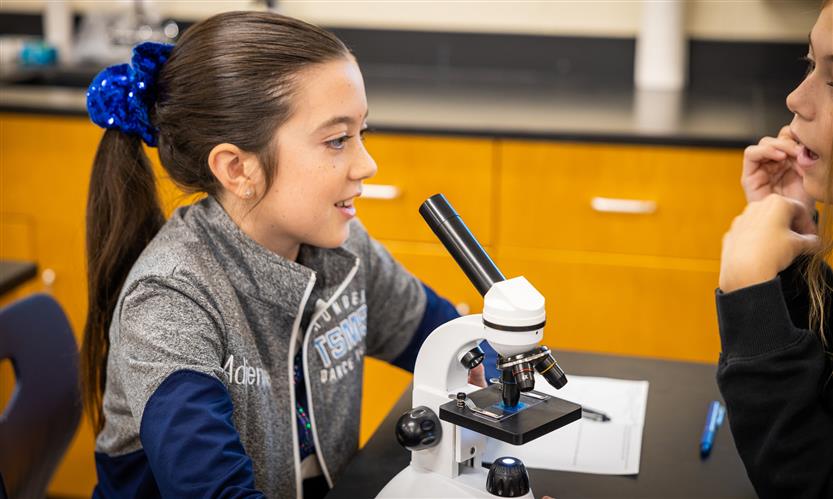 Students use microscopes in science class